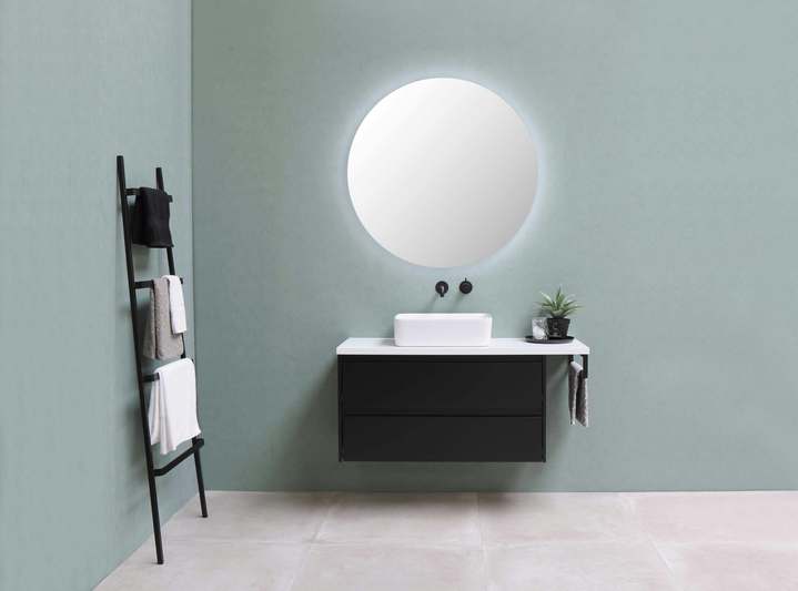 Editor testing a smart mirror with built-in display in a well-lit living space